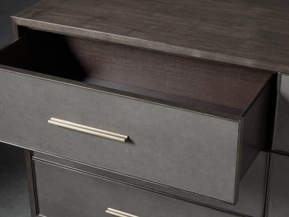 Close-up of the Malone Six-Drawer Dresser with its top drawer partially open, revealing dark wood interior, textured gray-brown front, and metallic pull handle.