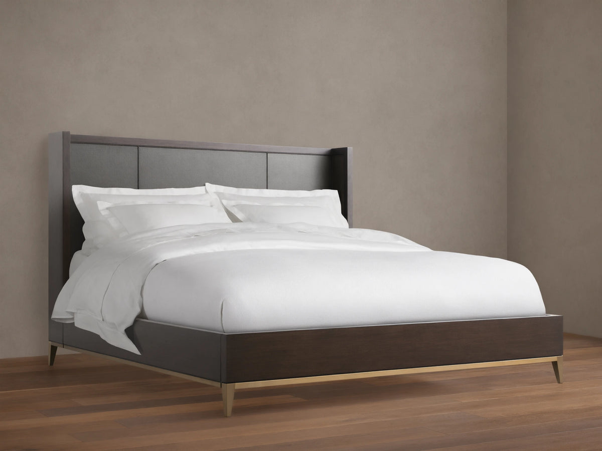 Malone Shelter Bed: dark wood frame, charcoal inset headboard, white bedding, metallic gold base on wood floor.