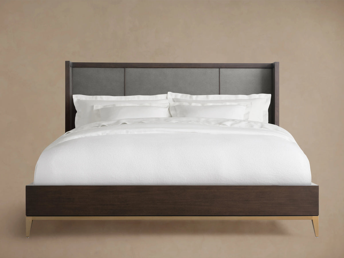 Malone Shelter Bed with dark walnut wood frame, grey leather headboard panels, white bedding, and metallic feet.