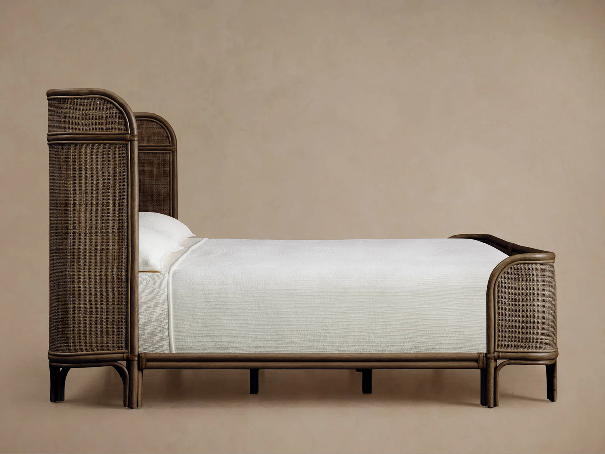Close-up of a Maya Bed headboard, highlighting its curved, hand-stained Manau rattan frame and intricate woven mesh.