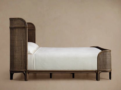 Close-up of a Maya Bed headboard, highlighting its curved, hand-stained Manau rattan frame and intricate woven mesh.