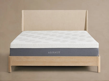 Memory Foam Firm Mattress on a light wood bed frame with a beige upholstered headboard, showing a textured white cover.