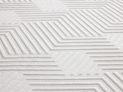 Mattress on a wooden bed frame with a beige headboard. The mattress has a white patterned top layer and gray sides with "Zarevium" branding.