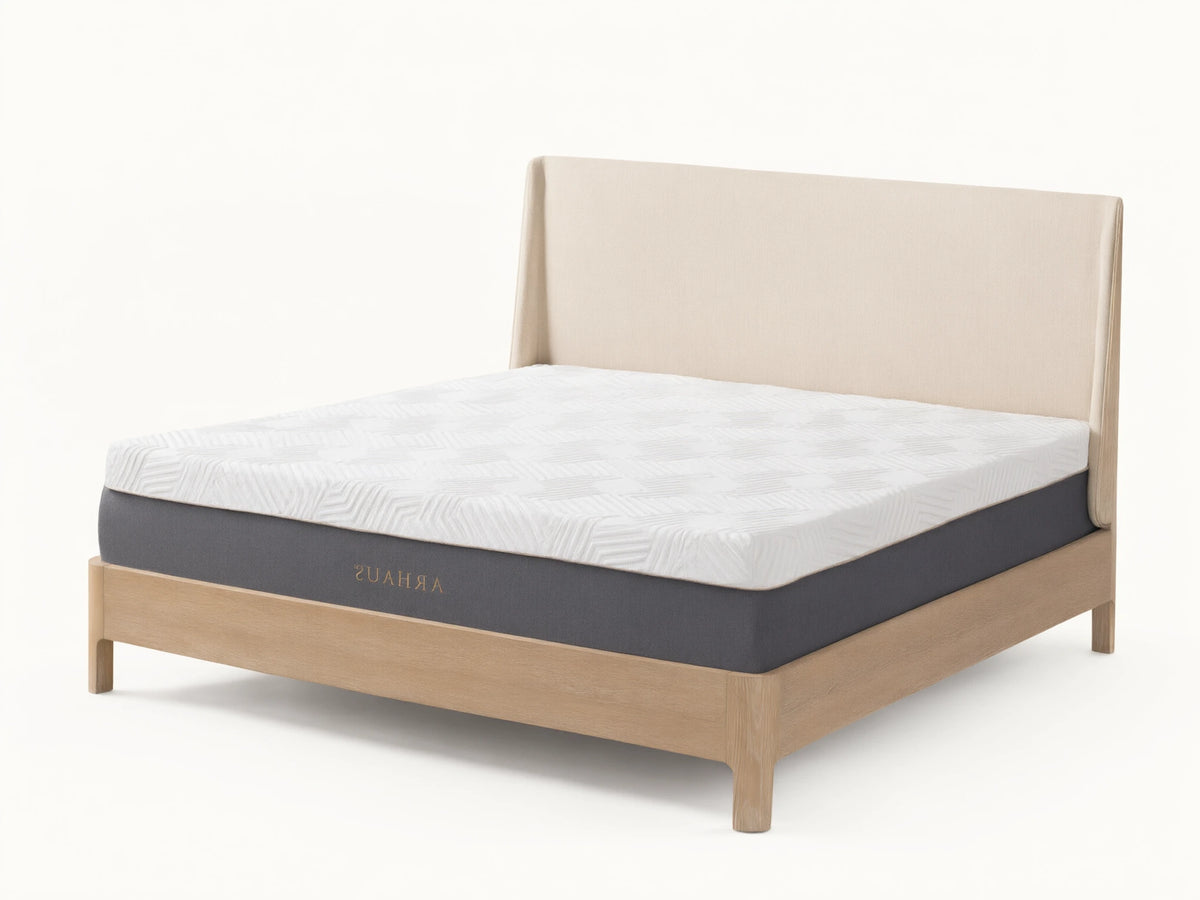 Memory foam plush mattress on a light wooden bed frame, featuring a white patterned surface and a gray base, in a minimalist bedroom.
