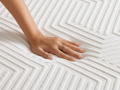 Memory Foam Plush Mattress on wooden bed frame, white geometric-patterned cover atop the gray base, corner view showing mattress layers.