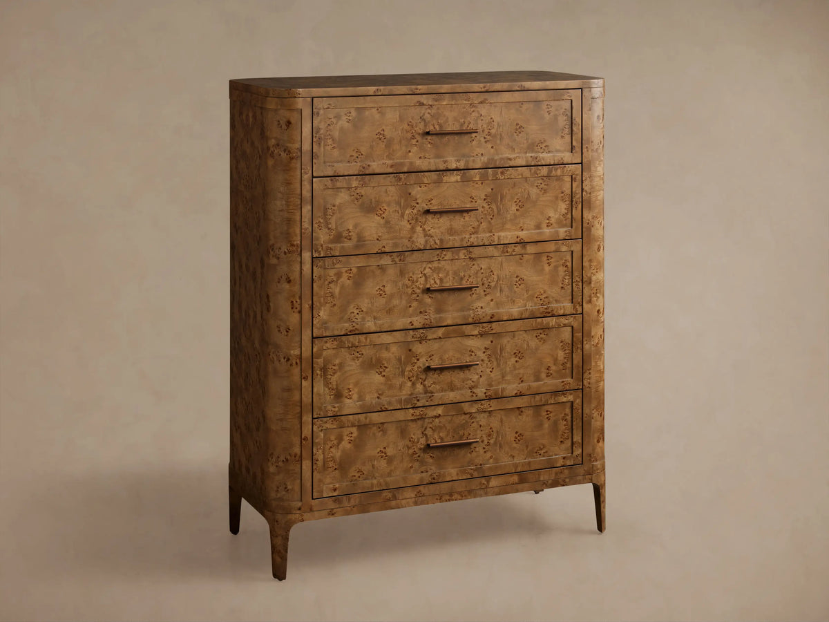 Front view of the brown Mogadore Five-Drawer Dresser, showcasing its mappa burl wood grain, five drawers, and antiqued brass pulls.