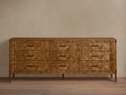 Front view of the Mogadore Nine-Drawer Dresser, made from brown mappa burl wood, featuring nine drawers with antiqued brass pulls.