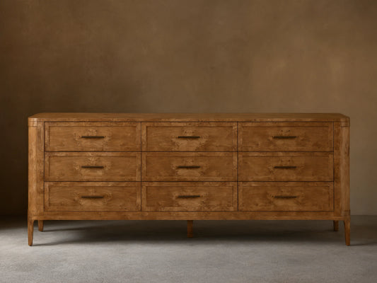 Front view of the Mogadore Nine-Drawer Dresser, made from brown mappa burl wood, featuring nine drawers with antiqued brass pulls.