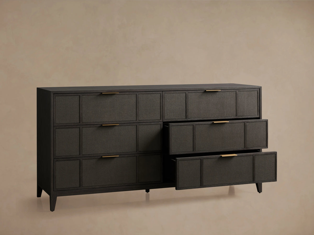 Olina Six-Drawer Dresser with dark oak finish, featuring raffia-textured front panels, six drawers, and brass pulls on wooden floor.
