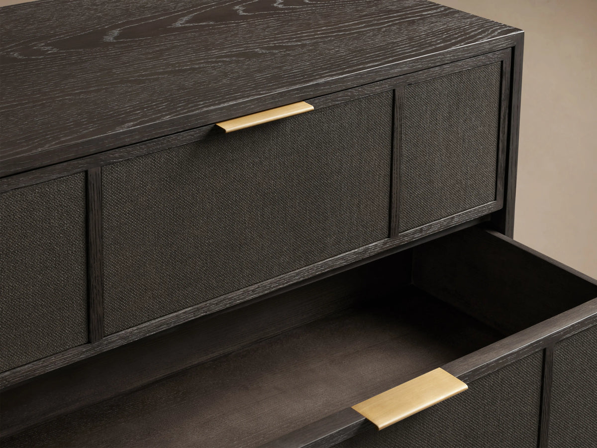 Olina Six-Drawer Dresser in dark oak with textured raffia fronts, three drawers slightly open, brass pulls visible.