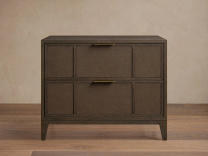 Olina Closed Nightstand in dark brown with two textured raffia front drawers, brass pulls, and a smooth top on angled legs.