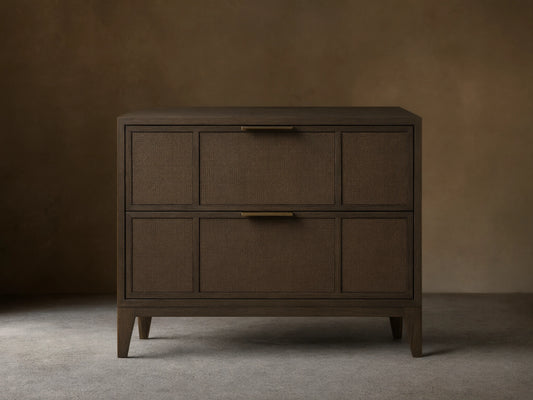 Olina Closed Nightstand in dark brown with two textured raffia front drawers, brass pulls, and a smooth top on angled legs.