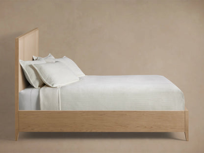Close-up of the Olina Bed headboard, featuring light oak wood framing with textured light beige raffia panels.
