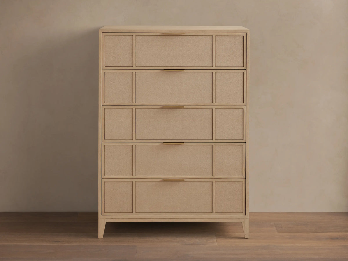 Front view of the natural oak Olina Five-Drawer Dresser, featuring five drawers with framed raffia panels and brass pulls.