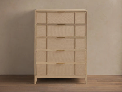 Front view of the natural oak Olina Five-Drawer Dresser, featuring five drawers with framed raffia panels and brass pulls.