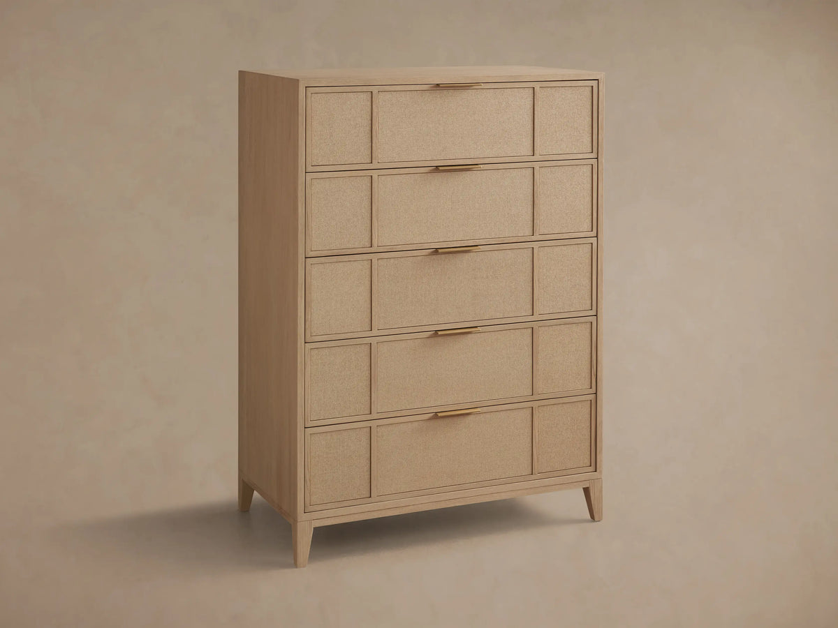 Close-up of the light wood Olina Five-Drawer Dresser. One textured raffia drawer with a brass pull is partially open.