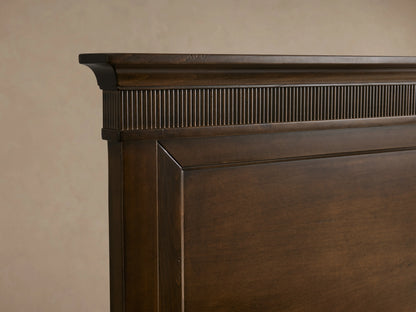 Ottavia Bed frame detail showing dark Tanganika wood with a fluted, hand-applied finish top edge on a smooth panel.