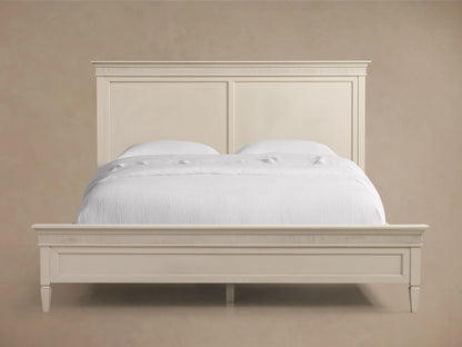 Ottavia Bed in a cream finish, featuring a craftsman-built wooden frame with a high headboard. Bed is neatly made with white bedding.