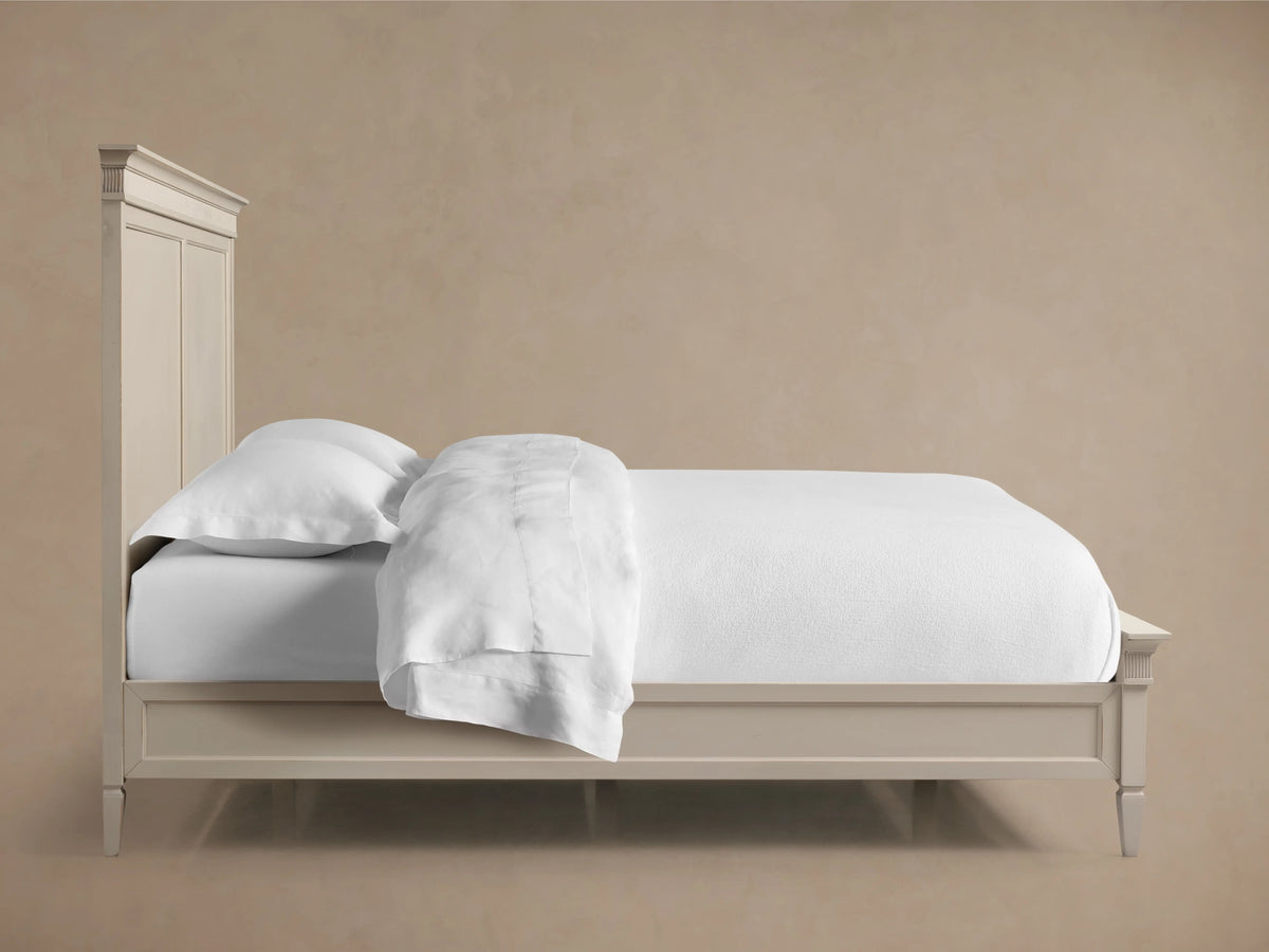 Ottavia Bed corner view showing a cream-colored headboard with ornate ridged detailing along the top edge.