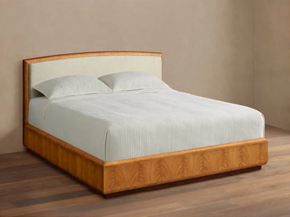 Front view of the Palma Bed with a cream upholstered headboard, distinctive cerajeira wood veneer frame, and white ribbed bedding.