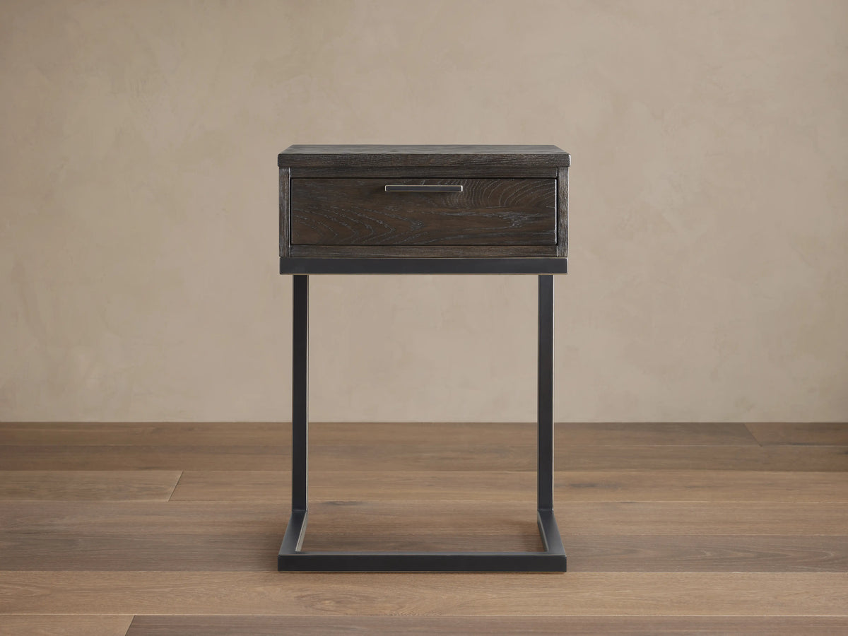 Palmer Storage Nightstand with a dark wood finish and a single drawer. Features a sleek, black iron frame in a Parsons style.