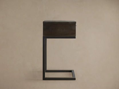 Palmer Storage Nightstand featuring a dark wooden drawer and a minimalist black iron Parsons-style frame against a beige background.