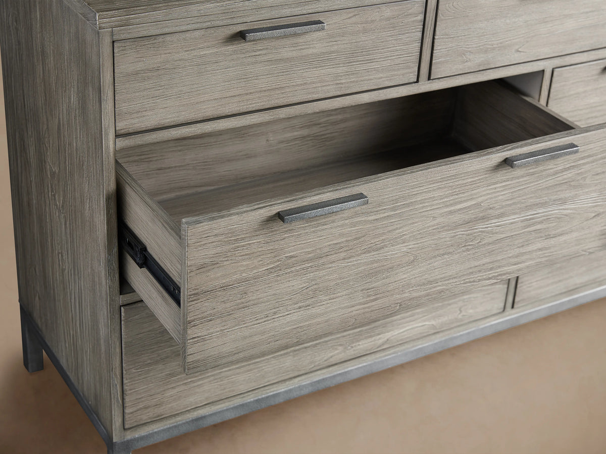 Palmer Seven-Drawer Dresser in a light wood finish with a partially open drawer. Features simple metal handles and sturdy iron frame.