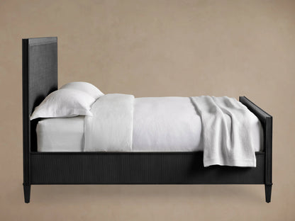 Dark-stained Pearson Cane Bed with textured cane headboard & footboard, dressed in white, on a wooden floor.