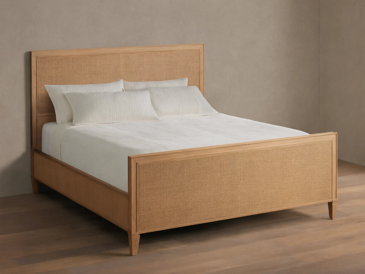 Front view of the natural wood Pearson Cane Bed, featuring a woven cane headboard and footboard, dressed with white bedding.