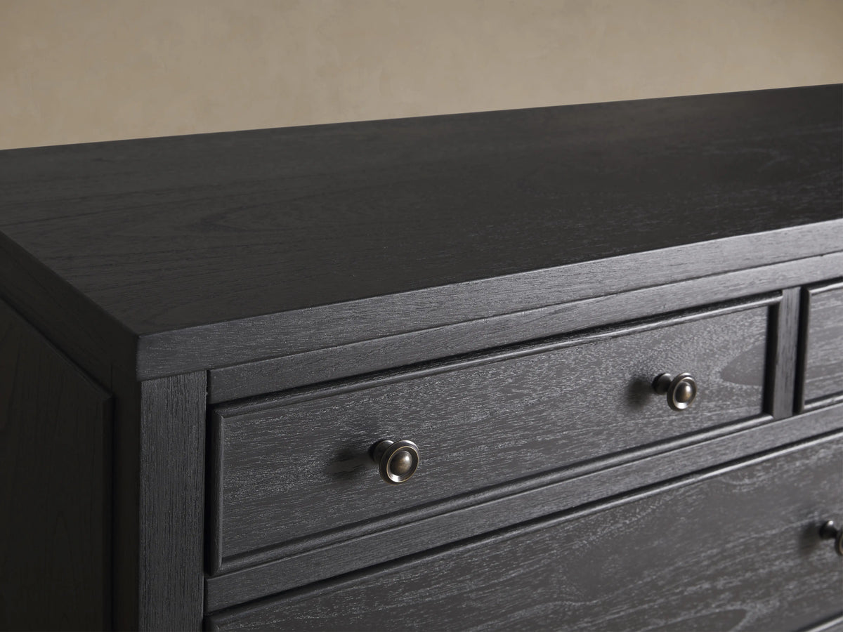 Pearson Eleven-Drawer Dresser in dark wood with hand-carved, curved molding. Features small, round handles and stands on four tapered legs.