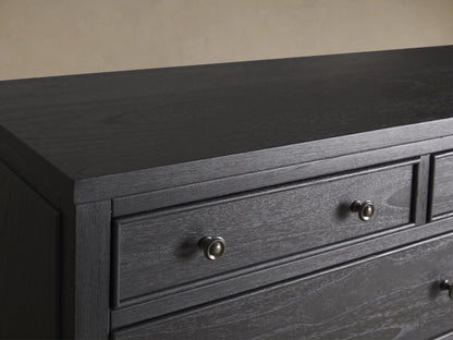 Pearson Eleven-Drawer Dresser in dark wood with hand-carved, curved molding. Features small, round handles and stands on four tapered legs.