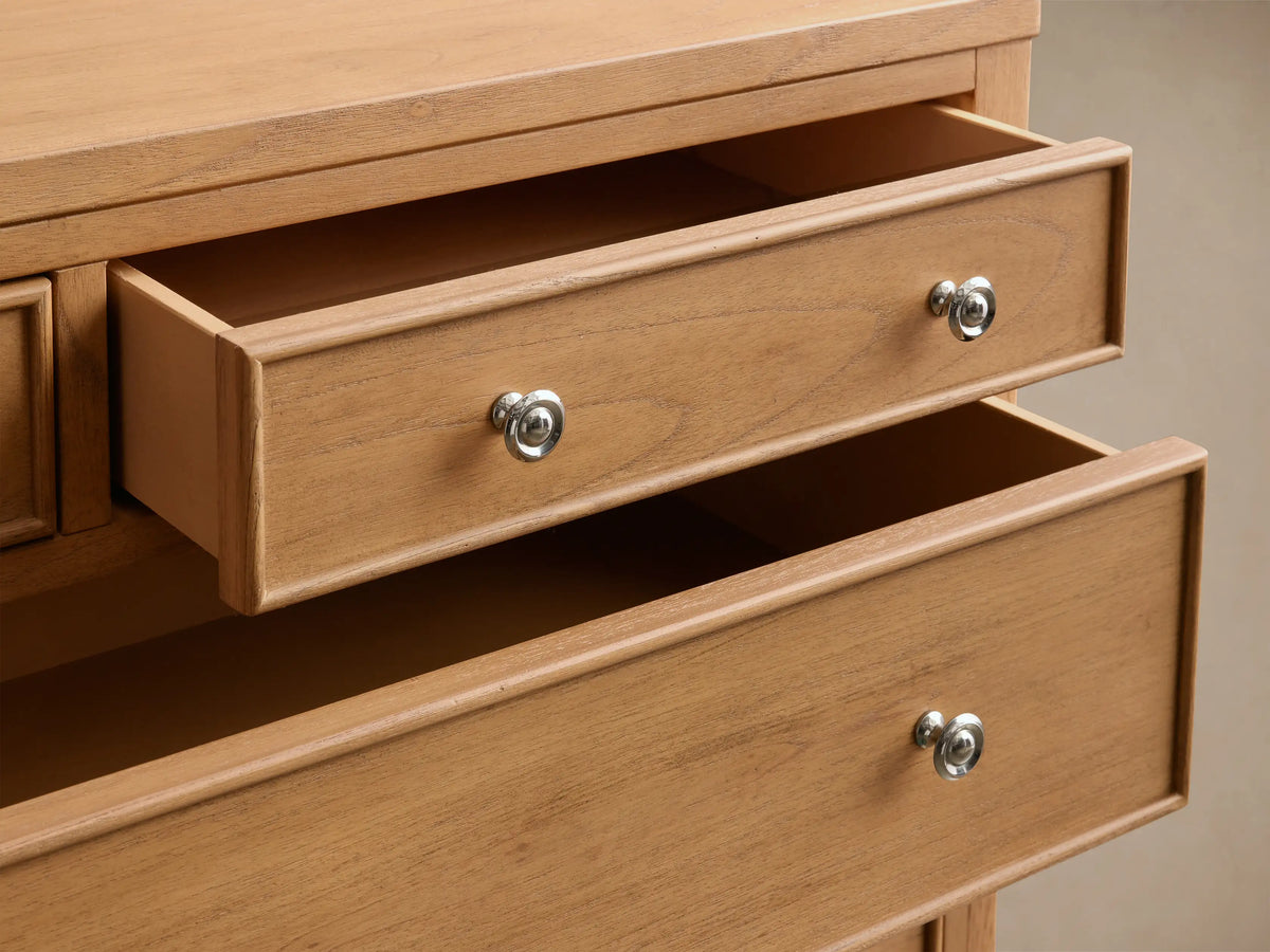Close-up of two partially open drawers of the light brown Pearson Eleven-Drawer Dresser, with curved molding and silver-toned pulls.