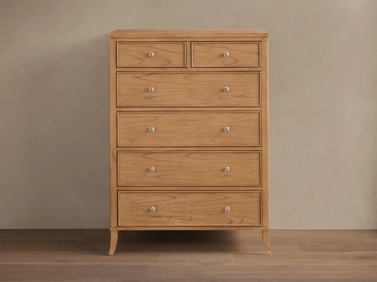 Front view of the natural wood Pearson Six-Drawer Dresser with silver knobs and curved molding on drawer fronts.