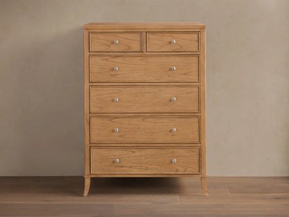 Front view of the natural wood Pearson Six-Drawer Dresser with silver knobs and curved molding on drawer fronts.