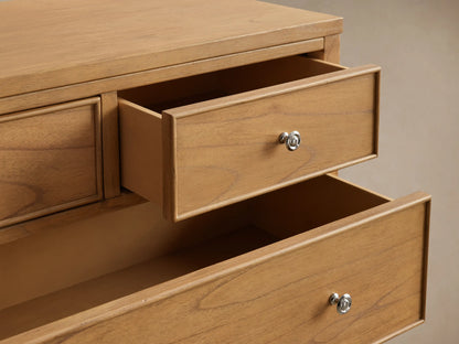 Front view of the natural wood Pearson Six-Drawer Dresser with silver knobs and curved molding on drawer fronts.