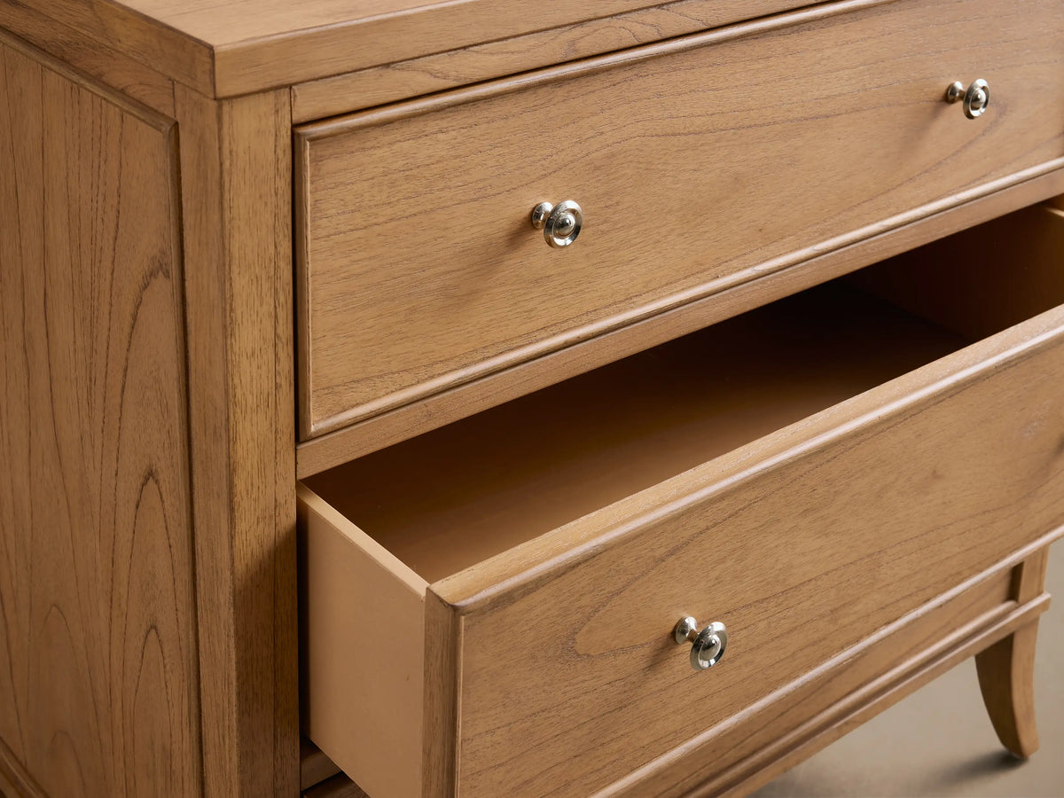 Close-up angled view of a natural wood Pearson Three-Drawer Chest with framed drawer fronts, one drawer open, and silver knobs.