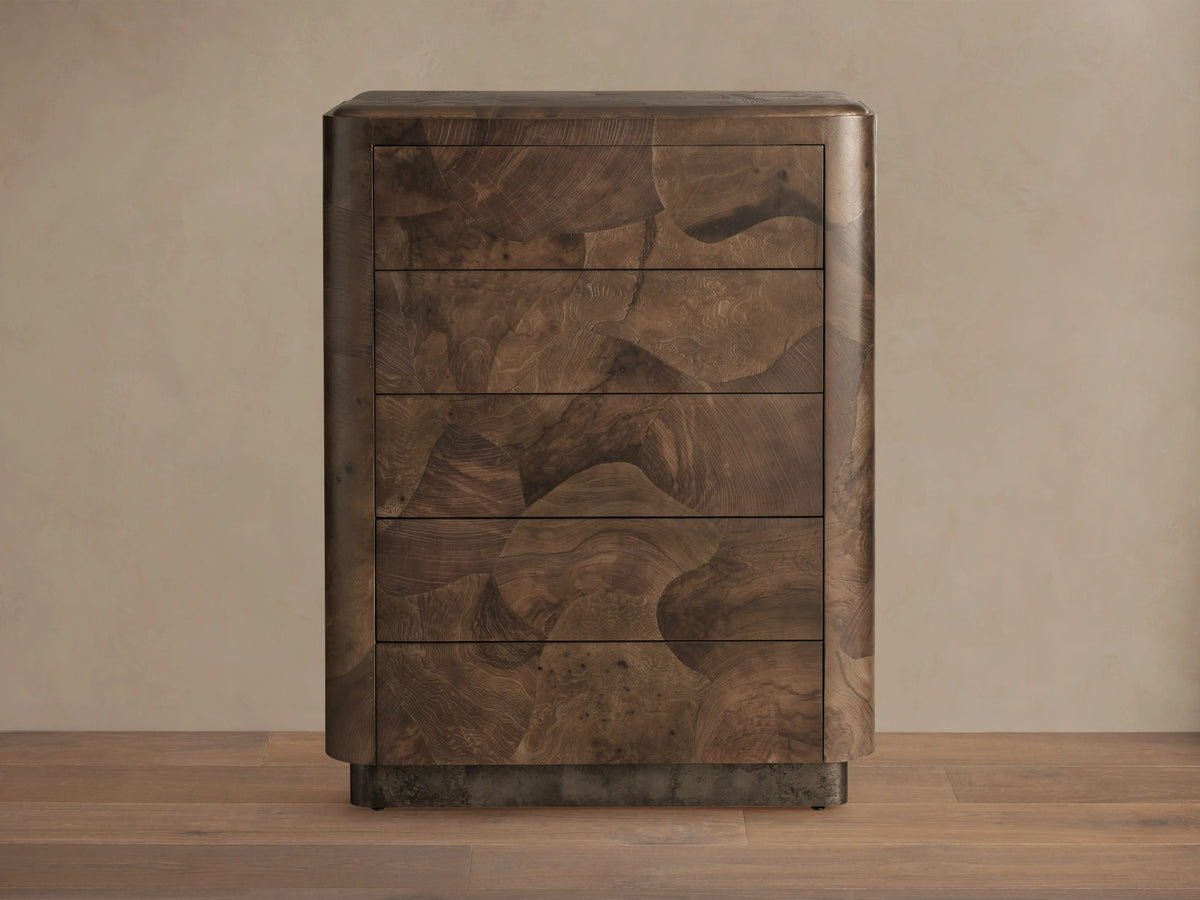 Polanco Five-Drawer Dresser made from dark oyster-cut wood with visible graining and natural patterns, and steel base with patina.