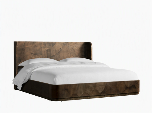 Bed made from dark wood with natural grain pattern, featuring a headboard. White bedding on a sturdy, low frame on wooden floor.