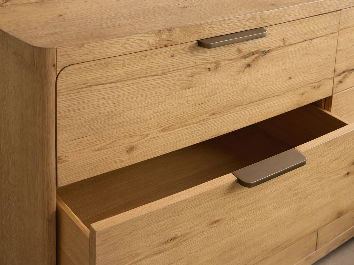 Front view of light oak Redding Six-Drawer Dresser with rounded edges, six drawers, and dark bronze pull handles.