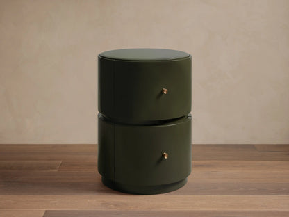Riya Round Nightstand: high-gloss dark olive green finish, two stacked drawers with brass knobs, on a wood floor.