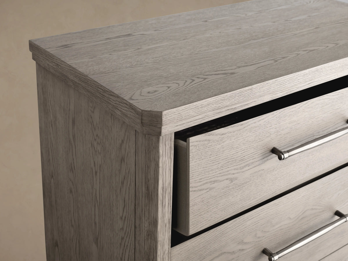 St. Martin Five-Drawer Dresser in Haze finish features pewter hardware, crafted from oak with soft-close glides, shown against a neutral background.