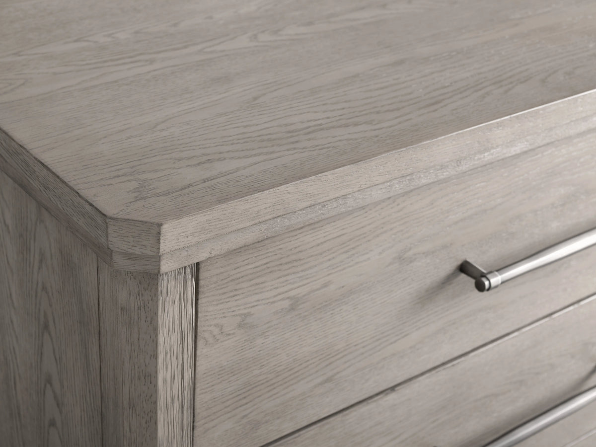 St. Martin Six-Drawer Dresser in light wood, features six drawers with pewter-finished handles, on tapered legs, against a beige background.