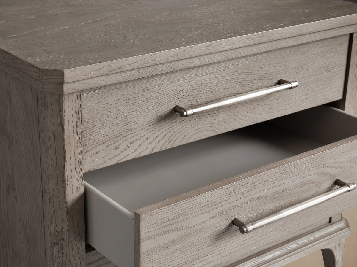 St. Martin Closed Nightstand in light oak, featuring three drawers with pewter-finished handles and elegant tapered legs.