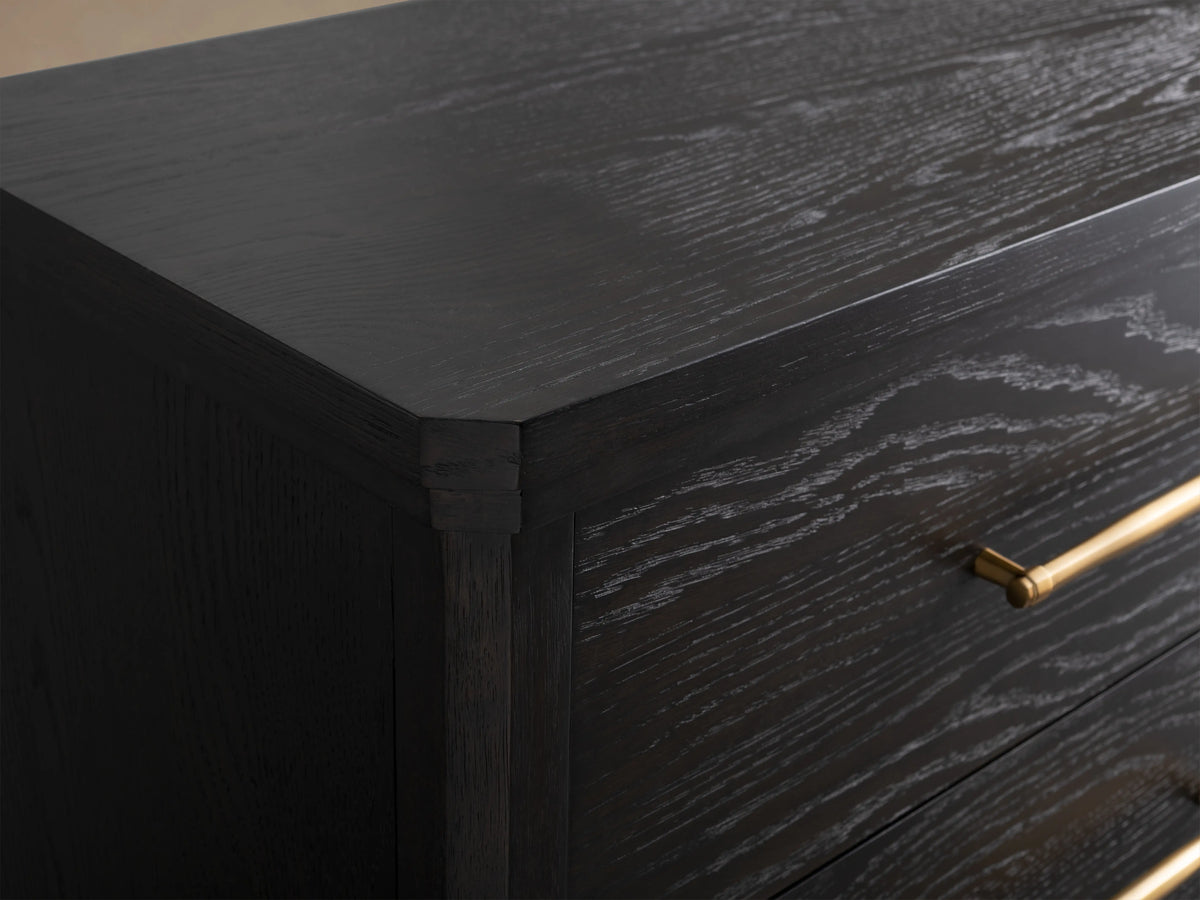 Close-up of the St. Martin Five-Drawer Dresser in a dark finish. The oak wood shows a textured grain with brass-finished handles.