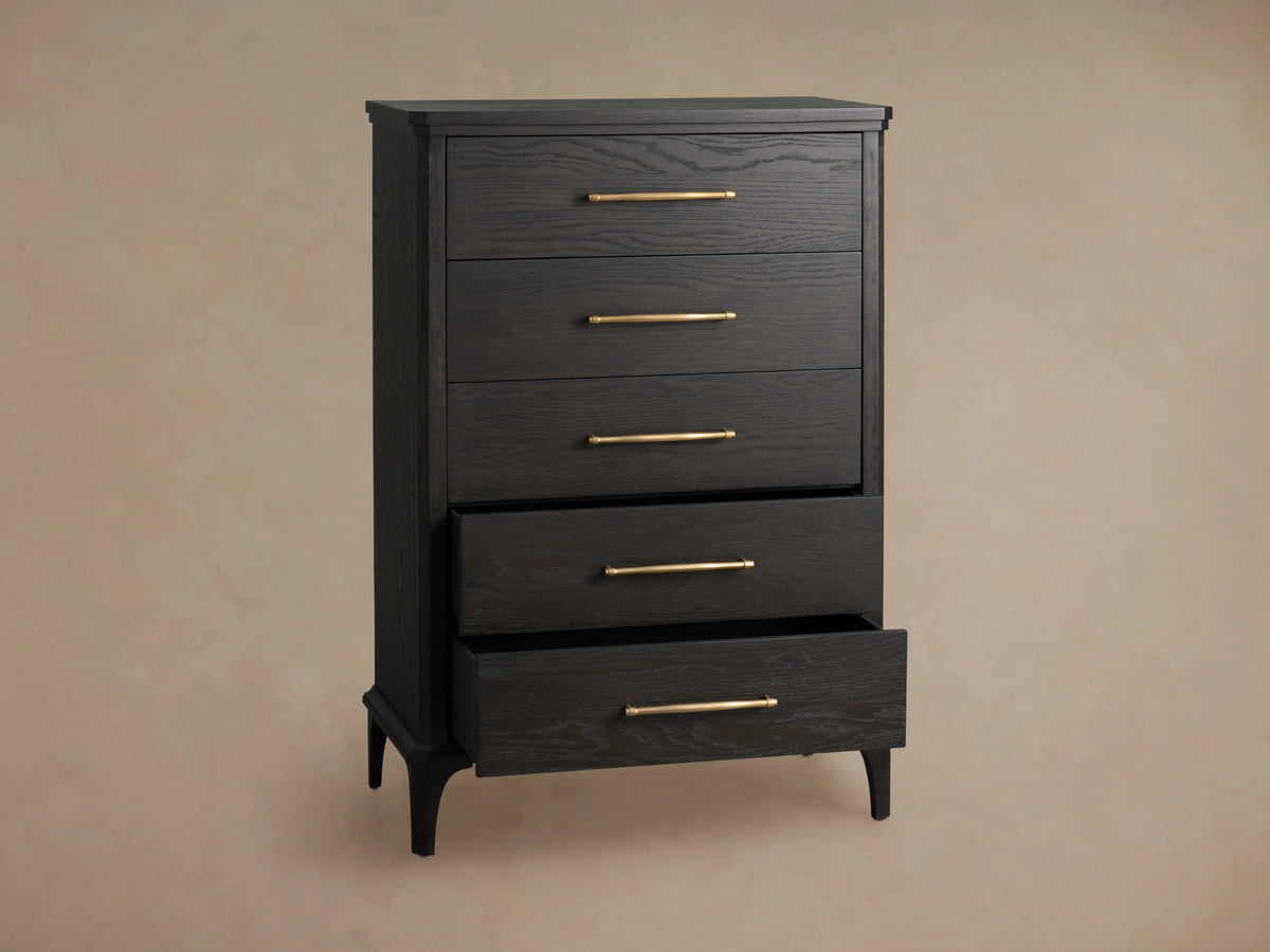 St. Martin Five-Drawer Dresser in dark oak with a Smoke finish, featuring brass-finished handles, against a beige wall.