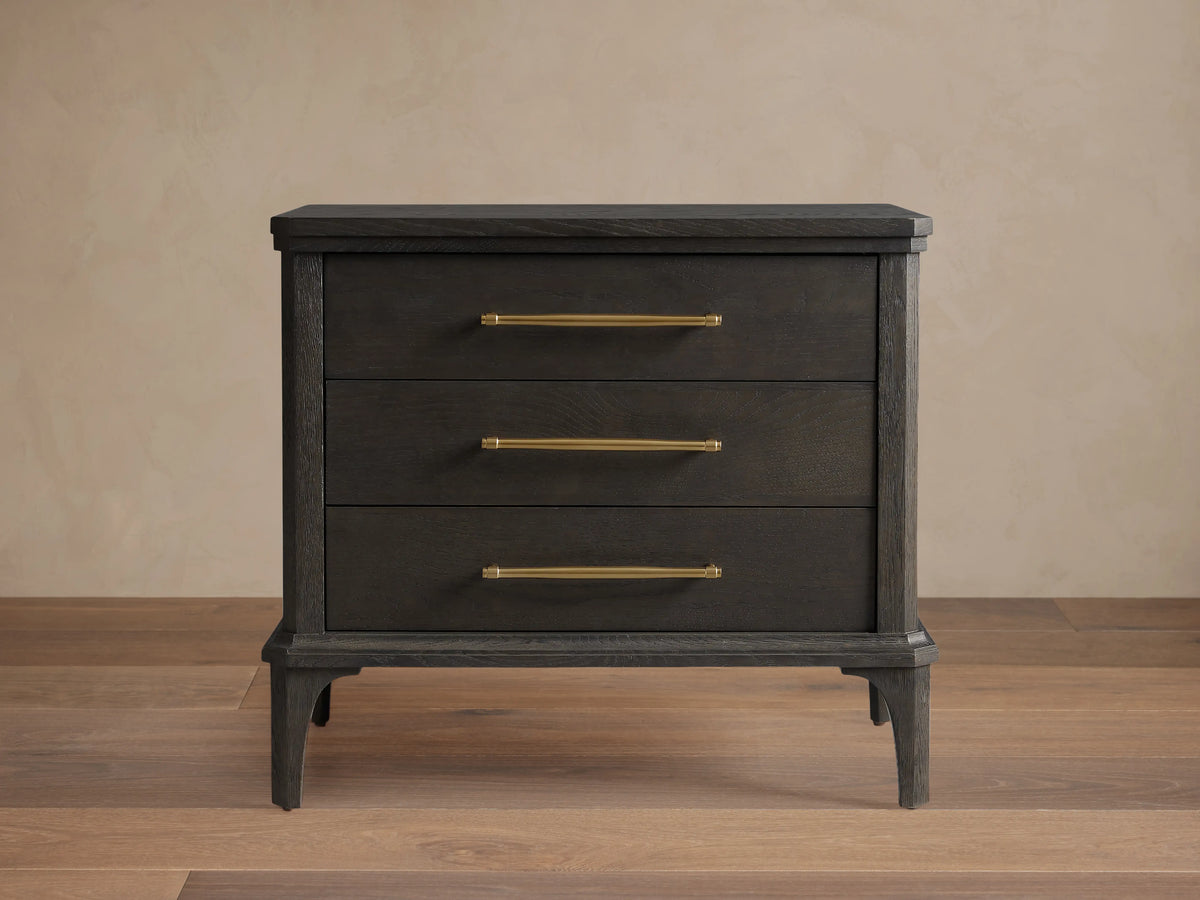 St. Martin Closed Nightstand shown in dark oak finish with three drawers. Brass-finished handles complement its craftsman design.