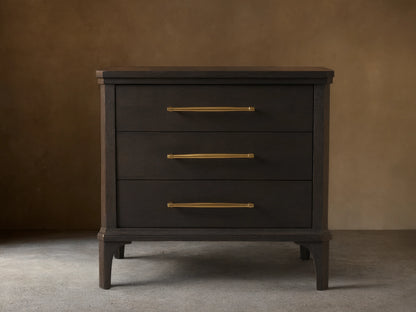 St. Martin Closed Nightstand shown in dark oak finish with three drawers. Brass-finished handles complement its craftsman design.