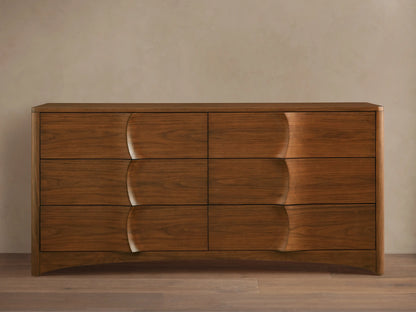 Westyn Six-Drawer Dresser: Warm brown walnut wood with 6 drawers, featuring unique carved, concave wave-like fronts.