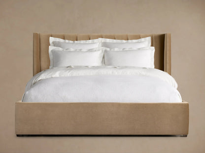Wyller Channel-Stitched Bed with a tall, channel-stitched tan headboard, low footboard, and white bedding on a wood floor.