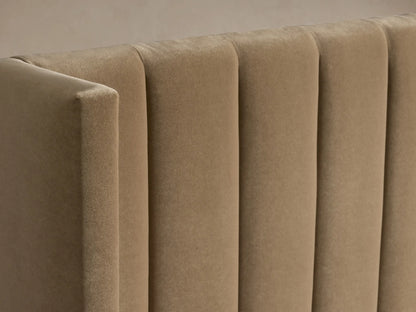 Wyller Channel-Stitched Bed. Beige upholstered frame with vertical channel-stitched headboard, low footboard, and white bedding.